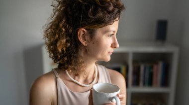 Bir kadın Kafkas girişimci iş kadını ya da sekreteri iş yerinde durmuş bir fincan kahve içiyor ve bir fotokopi çekiyor.