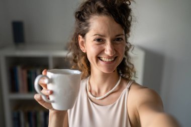 Beyaz kadın girişimci işkadını ya da sekreter iş yerinde kahve içip fren yapan mutlu bir gülümseme alan bir kadın.