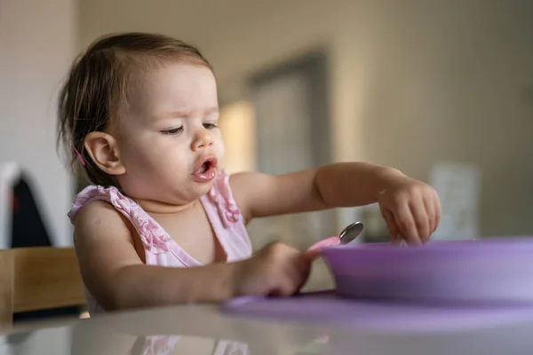 1人の子供小さな白人の幼児女性の赤ん坊はテーブルで一人で家で食べる現実の人々はスペースをコピーします — ストック写真