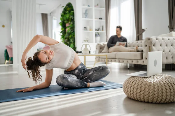 Genç Beyaz Bir Kadın Evde Oturmuş Yoga Dersleri Alıyor Kocasının — Stok fotoğraf