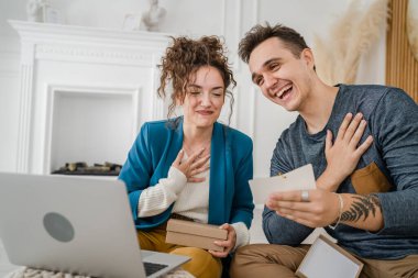 Kafkasyalı genç bir çift, karı-koca, karı-koca ya da erkek arkadaş hediye kutusunu açıyor ve evdeki dizüstü bilgisayarın önünde internetten fotokopi odası arıyor.