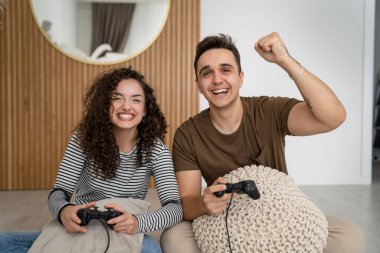 İki kişi, çift erkek ve kadın sevgili karı koca ya da arkadaşlar oyun oynuyorlar kumanda kumandası ellerinde mutlu bir gülümseme duygusal bir jest kazanıyorlar aile reaksiyonlarını kopyalıyorlar