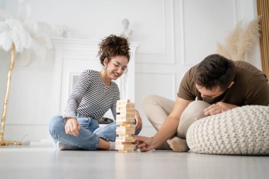 Kadın ve erkek mutlu beyaz çift ya da evde Jenga masası oyunu oynayan arkadaşlar mutlu bir gülücük keyfi birlikte vakit geçiriyorlar aile zamanlarını kopyalayan gerçek insanlar.