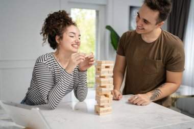 Kadın ve erkek mutlu beyaz çift ya da evde Jenga masası oyunu oynayan arkadaşlar mutlu gülücükler, boş zaman geçirerek birlikte vakit geçiriyorlar aile ortamını kopyalayarak gerçek insanları kopyalıyorlar.