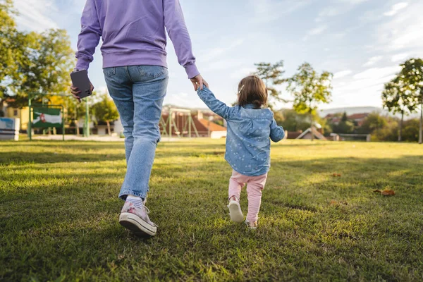 未知の母と子の女と娘の風景女は公園を歩きながら手を握り大人と18ヶ月の母親と子供時代は家族のコンセプトコピースペースを1日で育て — ストック写真