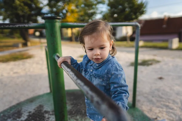 1人の女の子小さいCaucasian子供女性幼児18ヶ月で公園遊びで日にスピーディーなスピナーメリーゴーランドターンアバウト子供時代と成長のコンセプトコピースペース — ストック写真