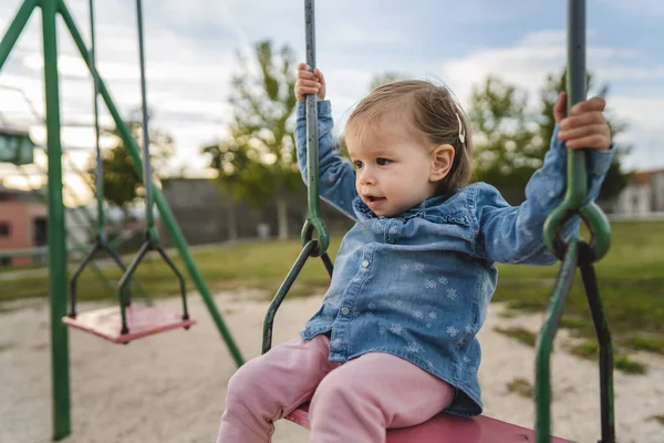 1人の女の子小さな白人の子供女性幼児18ヶ月楽しいを持っています公園で一人でスイングで日子供時代と成長コンセプトコピースペース — ストック写真