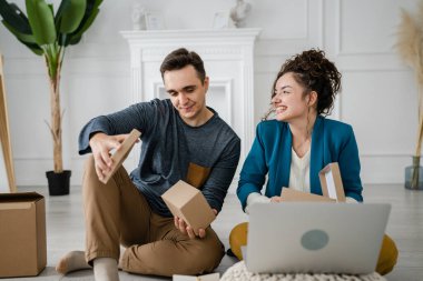 Genç çift erkek ve kadın erkek ve kız arkadaş ya da karı koca hediyelerini evde değiştirip birbirlerine hediye veriyorlar ve mutlu bir gülümseme açıyorlar sevgililer günü bayramı ya da doğum günü kutluyorlar.