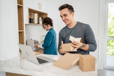 Kafkasyalı genç bir çift, karı-koca, karı-koca ya da erkek arkadaş hediye kutusunu açıyor ve evdeki dizüstü bilgisayarın önünde internetten fotokopi odası arıyor.