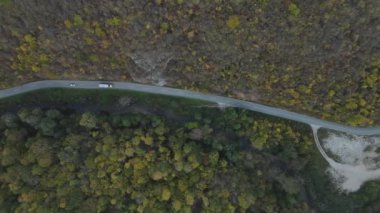 Sonbahar günü araba ve kamyon yolda giderken ağır taşıma araçları asfalt tepede asfalt hava aracı görünümünde otomobil kullanım konsepti 