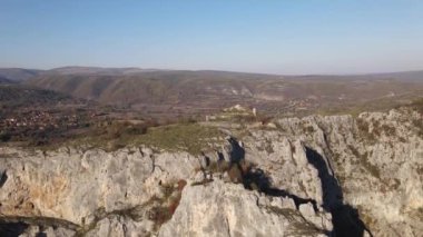 Sırbistan 'daki Svrljig yakınlarındaki Nisevac taştan kayalar ve güneşli bir günde tepedeki hava aracı videosunda dağ sırasındaki kayaları dolduruyor 