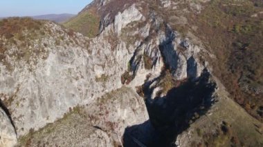 Sırbistan 'daki Svrljig yakınlarındaki Nisevac taştan kayalar ve güneşli bir günde tepedeki hava aracı videosunda dağ sırasındaki kayaları dolduruyor 