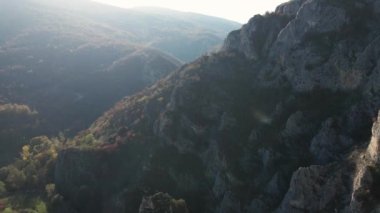 Sırbistan 'daki Svrljig yakınlarındaki Nisevac taştan kayalar ve güneşli bir günde tepedeki hava aracı videosunda dağ sırasındaki kayaları dolduruyor 