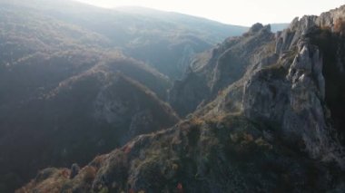Sırbistan 'daki Svrljig yakınlarındaki Nisevac taştan kayalar ve güneşli bir günde tepedeki hava aracı videosunda dağ sırasındaki kayaları dolduruyor 