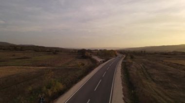 Otomobil geçen araçlarla yol manzarası sonbahar günü asfalt üzerinde yol alıyor kırsal alanda tarlalar boyunca doğa manzaralı seyahat konsepti