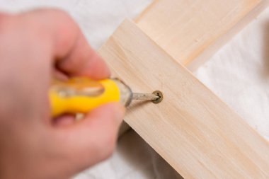 Marangozların atölyesinde elinde tornavida vidası olan bir adam. Kapat, seçici odaklan ve boşluğu kopyala