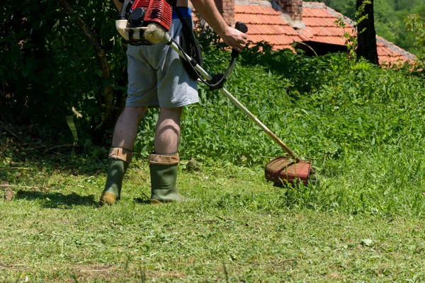 농부는 여름철에는 잔디깎는 기계로 뒷마당에 잔디를 깎았다 잔디깎는 정원가꾸기 — 스톡 사진