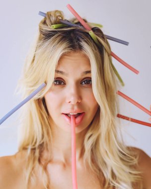 İçkili sarışın ve doğal ürünlerden yapılmış pipetli olan gülümseyen bir içki içer. Sıfır atık