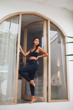 Camın yanında spor kıyafetlerini sergileyen tatlı Asyalı kız.