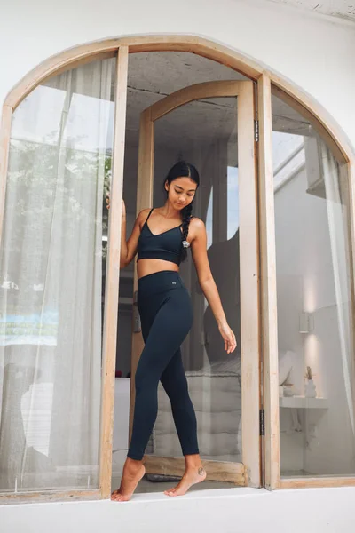 Camın yanında spor kıyafetlerini sergileyen tatlı Asyalı kız.