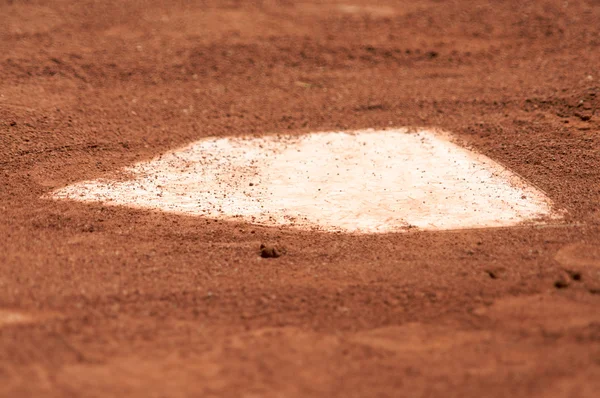 A baseball home plate is surrounded by dirt and shallow depth of field. — Stock Photo, Image