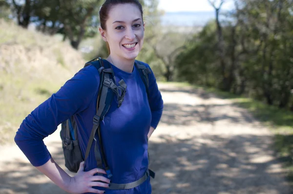 Wandelaar vrouw in blauwe lange mouw shirt kijkt naar de camera — Stockfoto