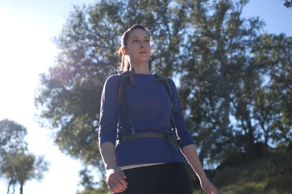 Frontal centered close up of woman hiking in blue shirt facing right — Stock Photo, Image