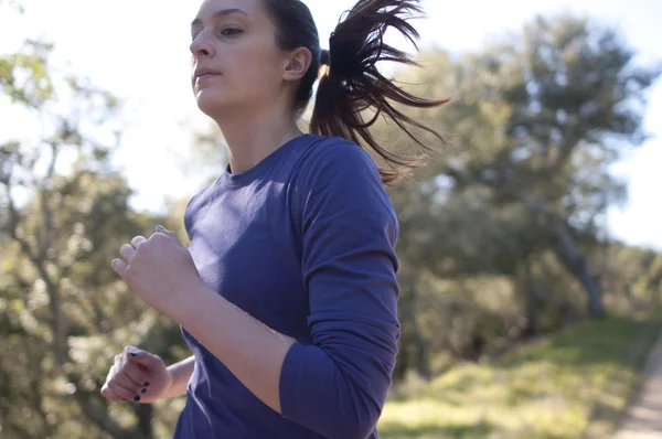 Very close up of woman jogging, facing left