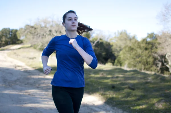 Skupia blisko się kobiety jogging poza, w obliczu prawa — Zdjęcie stockowe