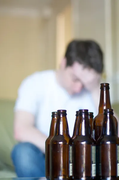 Vertikální, muž zvedl hlavu s prázdnou pivní láhve — Stock fotografie
