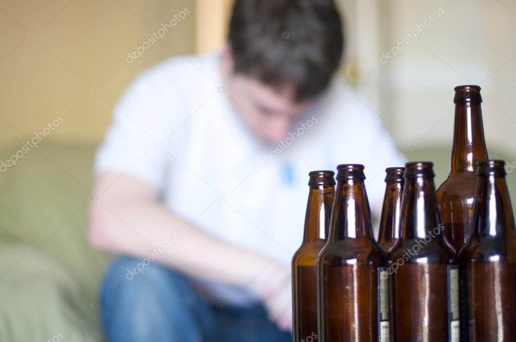 Man looks depressed with empty beer bottles