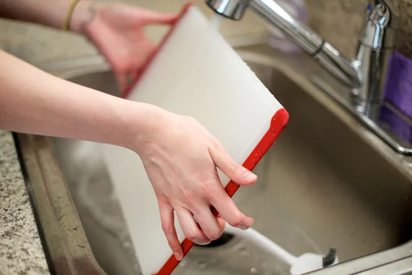 女性は、台所の流しのまな板を洗う ストック画像