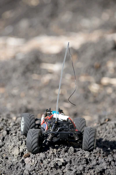 Veritcal of toy RC truck on dirt mound, no body — Stock Photo, Image