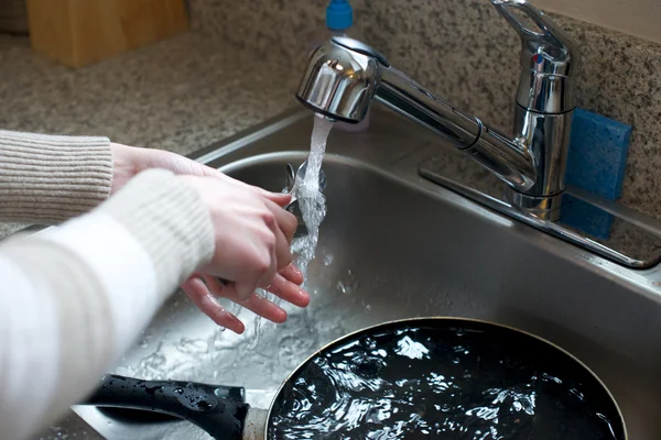 Close up of hands washing silverware — Stock Photo, Image