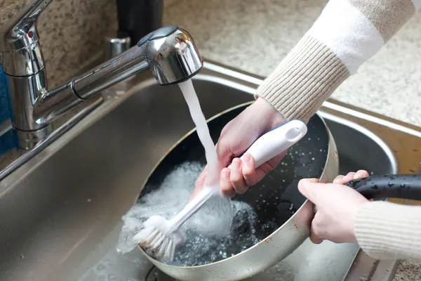 Close up of woman scrubbing pan — Stock Photo, Image