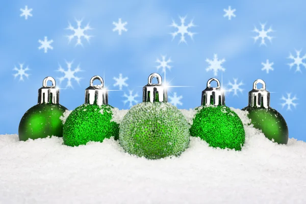 Groene kerstballen in de sneeuw — Stockfoto