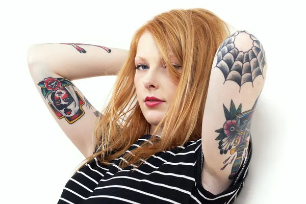 Aardbei blonde rode kop leunend tegen muur met tatoeage armen — Stockfoto