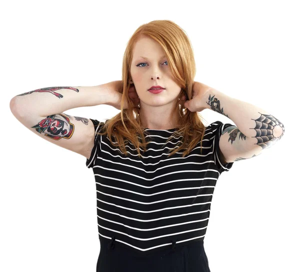 Aardbei blonde rode kop leunend tegen muur met tatoeage armen Stockfoto