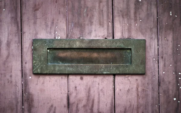 Verwitterter rostiger Briefkasten auf rotem Holz — Stockfoto