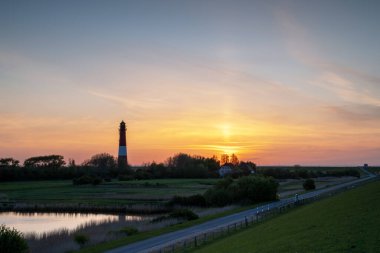 Panoramic image of Pellworm lighthouse against sunrise, North Frisia, Germany 
