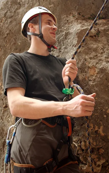 Joven escalando en una pared de piedra caliza con amplio valle en el fondo — Foto de Stock