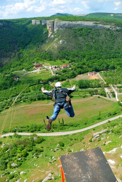 Springen van een rots met een touw. — Stockfoto