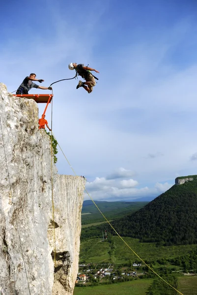 Hoppa från en klippa med ett rep. — Stockfoto