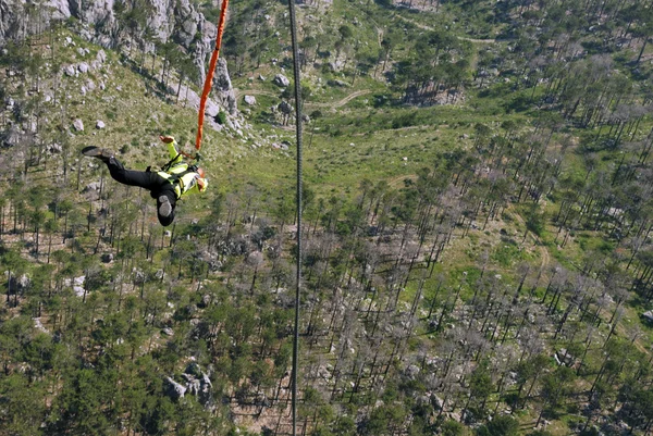 Jump off a cliff with a rope. — Stock Photo, Image