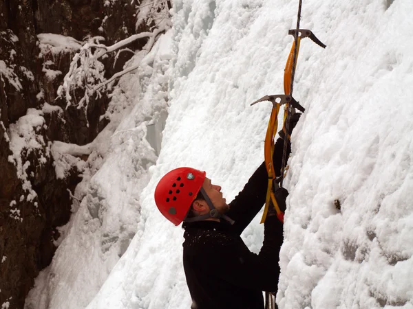 Man climbing frozen waterfall — Stock Photo, Image