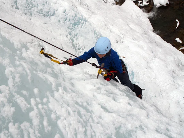 Man climbing frozen waterfall — Stock Photo, Image