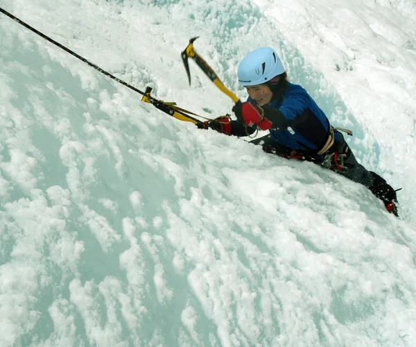 Man climbing frozen waterfall — Stock Photo, Image