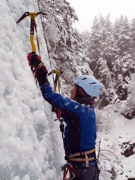 Man climbing frozen waterfall — Stock Photo, Image