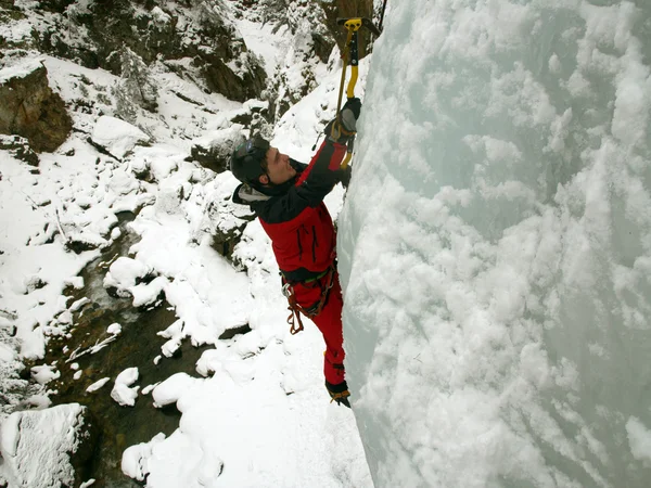 Man climbing frozen waterfall — Stock Photo, Image