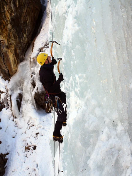 Man climbing frozen waterfall — Stock Photo, Image